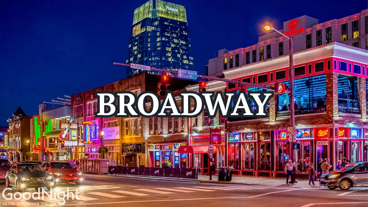 A vibrant nighttime street scene along downtown Nashville, featuring glowing neon signs, a variety of buildings, and people walking along the bustling sidewalks. The image captures the energetic pulse of the city’s nightlife, with hints of dining, entertainment, and live performances in the area.