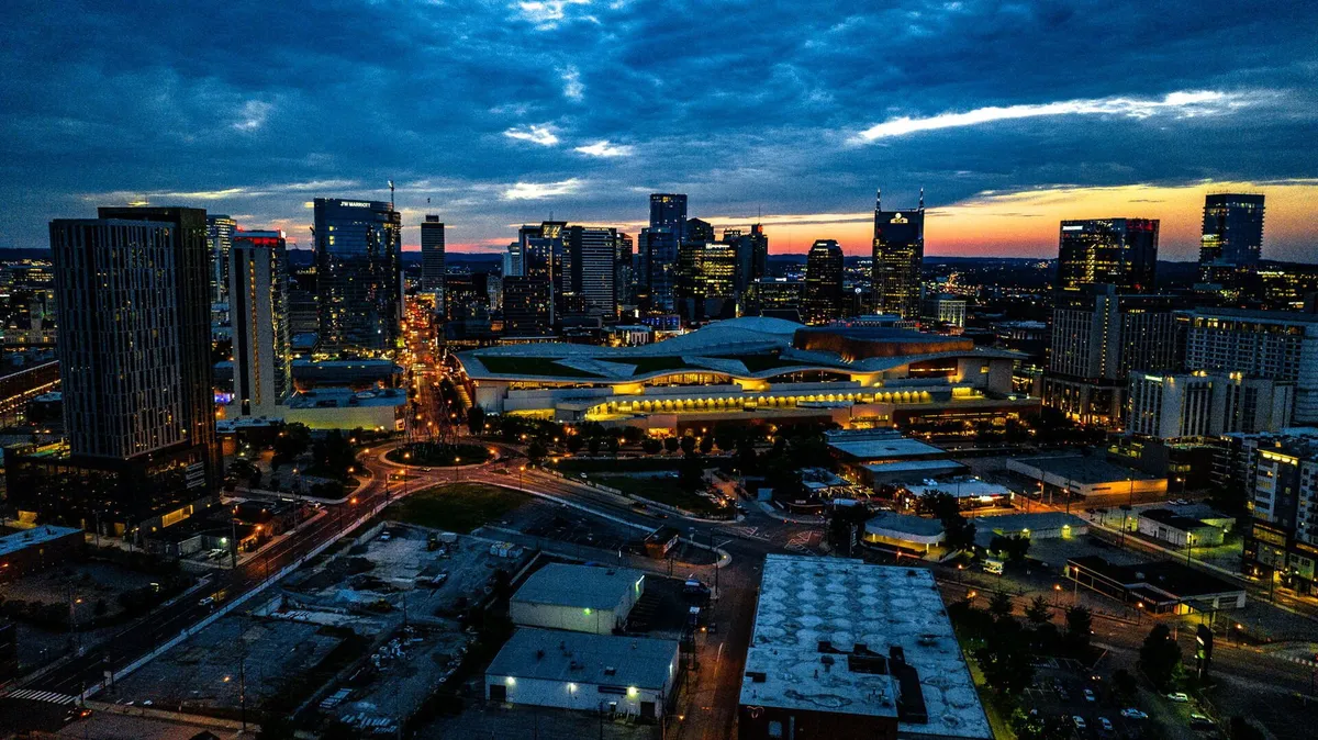 A panoramic night view of the Nashville city skyline, featuring illuminated buildings and bustling roadways. The city’s energy and glamour are on full display, evoking the rooftop terrace’s sweeping vistas mentioned in the section.