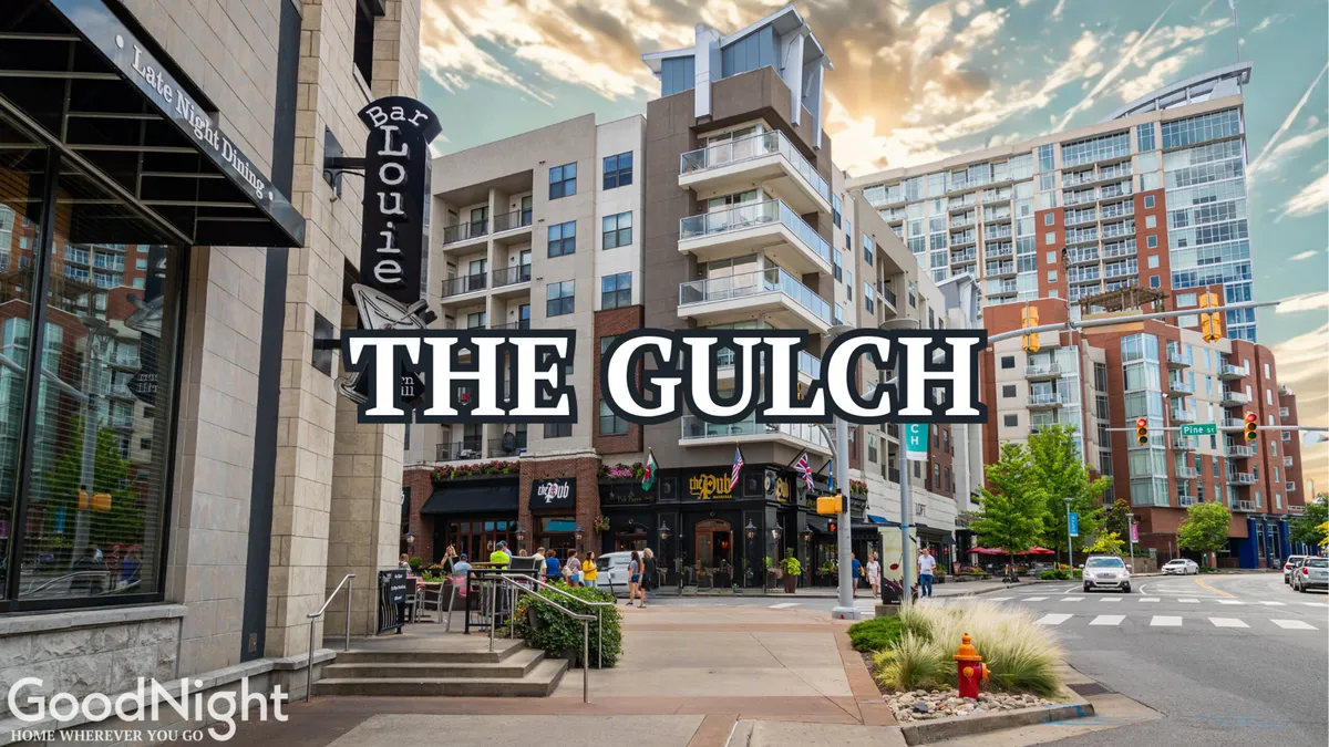 A lively downtown streetscape featuring Bar Louie, modern apartment buildings, people walking, and street signs. Outdoor cafes and shopping areas buzz with activity as the sun sets, giving the scene an energetic urban vibe.
